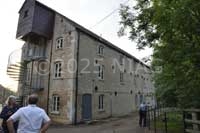 Eastern elevation of Grade II-listed early-19C Warmington Mill showing the lucom above the modern fire-escape stairs. &nbsp;The mill pond is behind the bushes on the right.